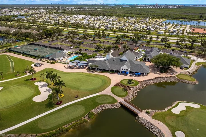 Aerial view of property's location featuring a golf club and nearby suburban area