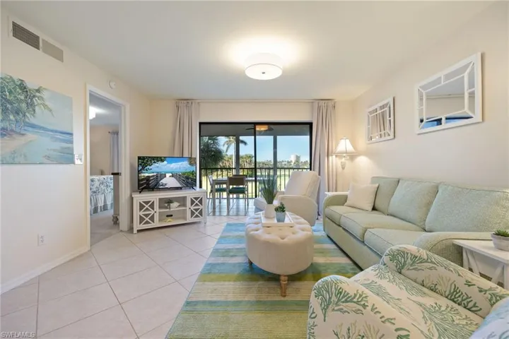 Living room with light tile patterned floors and new light fixtures.