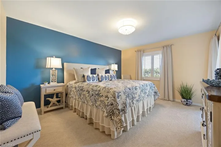 Primary Bedroom featuring NEW lush carpet and plantation shutters, new light fixtures.