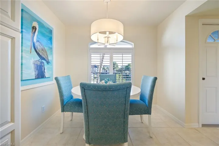 Dining in the kitchen area with plenty of natural light, plantation shutters and a new chandelier