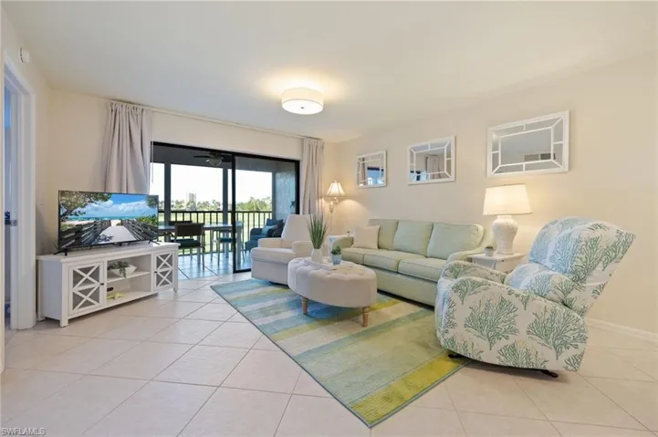Living area featuring light tile on diagonal, new neutral painted walls.