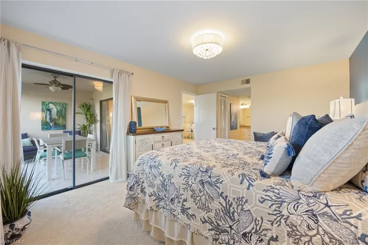 Bedroom featuring light NEW carpet, access to screened in lanai, with walk in closet.