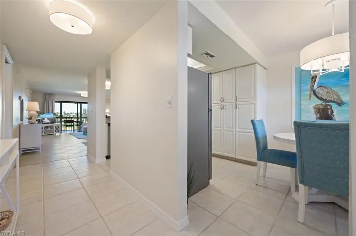Hall featuring light tile patterned flooring and baseboards