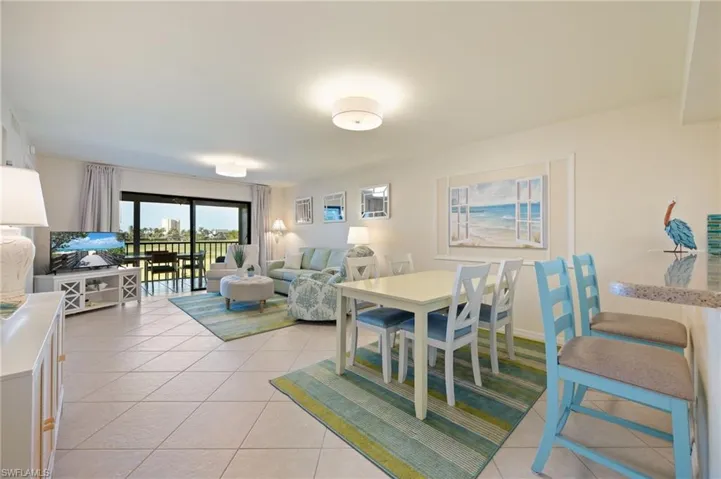 Great Open space with Dining area leading into living room with light tile floors on a diagonal.