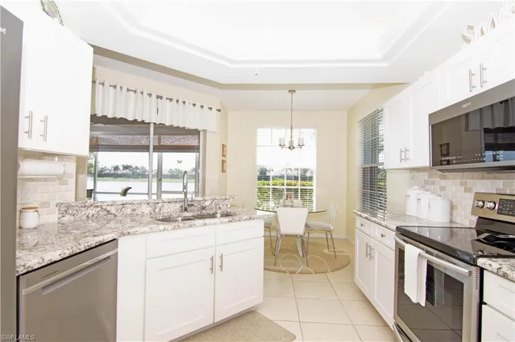 Kitchen offers ample light from 2 windows and a sliding glass door that leads to the screened lanai.