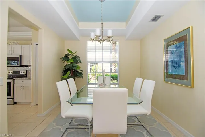 Spacious dining room with tray ceiling and chandelier accommodates 6-8 guests comfortably.