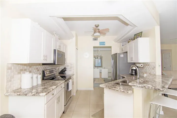 Enjoy preparing meals in this fabulous remodeled kitchen with shaker cabinetry; dimensional tile backsplash; attractive granite and stainless appliances.