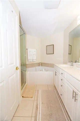 Updated primary bathroom features a double vanity, water closet, soaking tub and custom tiled shower.