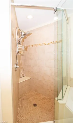 Oversized custom tiled shower in primary bathroom suite.