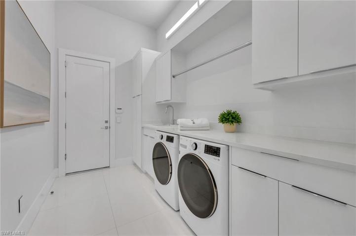 he laundry room off the garage has plenty of folding room and abundant, custom cabinetry.