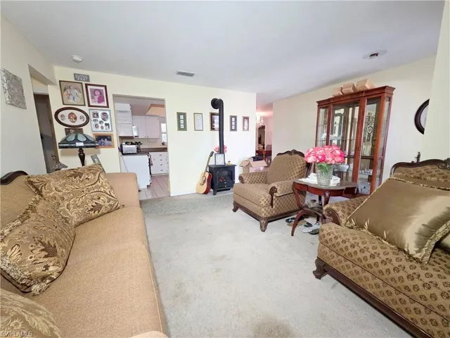 Carpeted living room featuring a wood stove