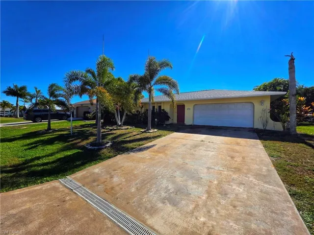 View of front of home with a front lawn, stucco siding, concrete driveway, and a garage