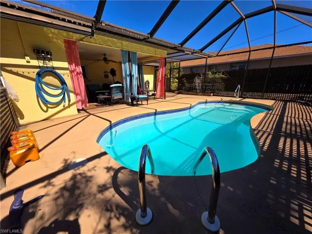 Outdoor pool featuring a lanai, a patio area, and a sunroom