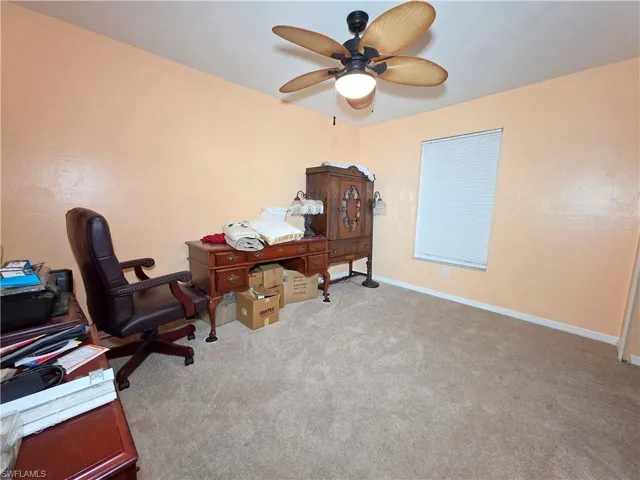 Office area with light colored carpet and a ceiling fan