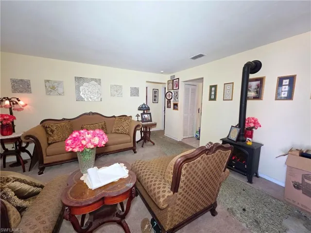 Living area featuring a wood stove and carpet flooring