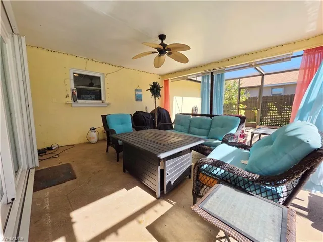 Sunroom featuring outdoor lounge area, ceiling fan, and a patio area