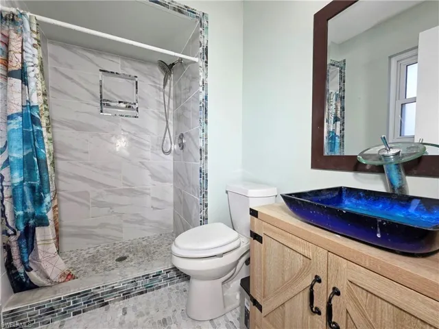 Full bathroom with vanity and a stall shower
