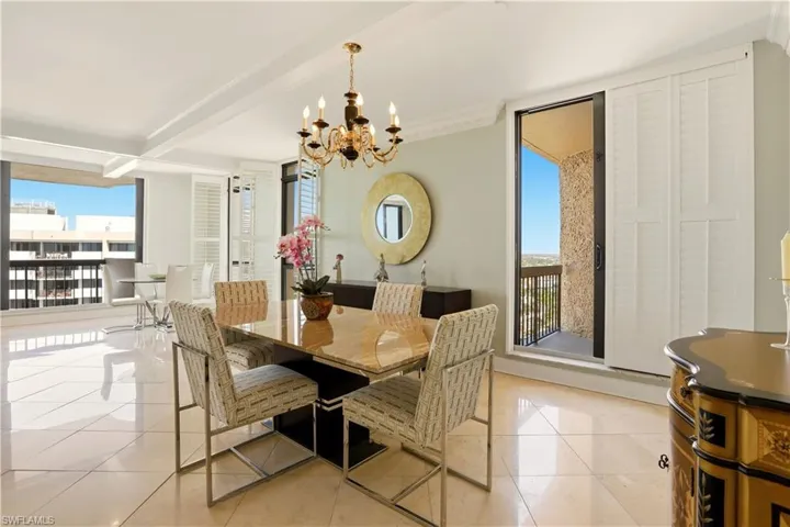 Dining area with light tile patterned floors, beamed ceiling, hanging lights, and plenty of natural light
