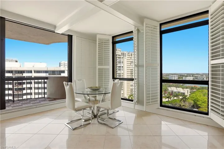 Dining area featuring beamed ceiling, light tile patterned floors, expansive windows, and a view of city