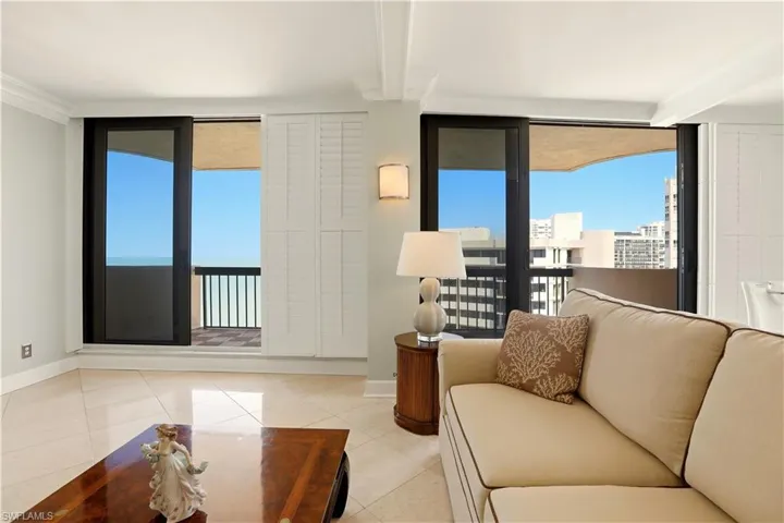 Living area featuring floor to ceiling windows, beam ceiling, light tile patterned floors, ornamental molding, and a water view