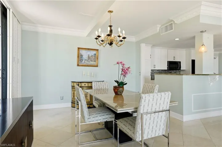 Dining room featuring ornamental molding, suspended lighting, and light tile patterned floors