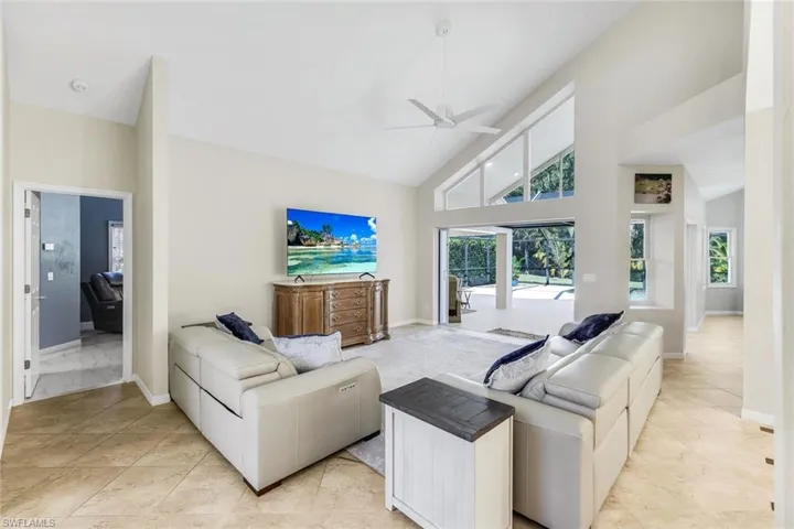 Light-filled living area featuring vaulted ceilings, abundant natural light, and seamless indoor-outdoor flow to the lanai.