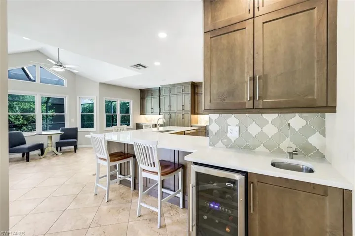 Wet bar with wine cooler, quartz countertops, and Waterdrop reverse osmosis system plumbed to both bar sink and refrigerator, ideal for entertaining.
