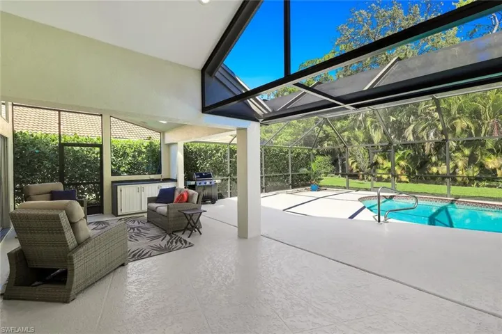 Expansive screened lanai with covered outdoor living area and poolside entertaining space.