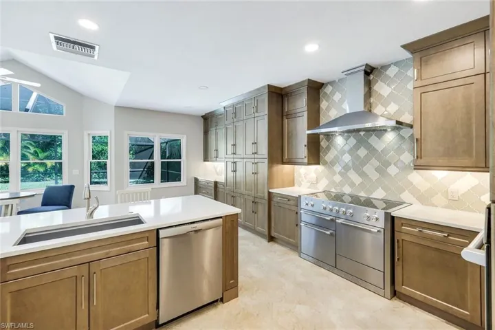 Chef-inspired kitchen showcasing quartz countertops, custom cabinetry, and a statement 48" AGA Mercury induction range with designer tile backsplash.