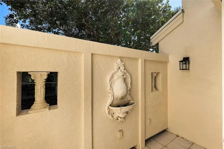 Charming courtyard detail featuring decorative wall fountain and private outdoor accent space.