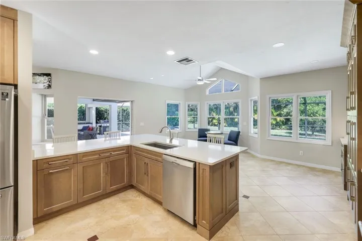 Light-filled kitchen with quartz surfaces and seamless connection to the breakfast and outdoor living areas.