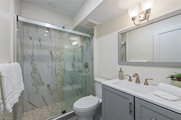 Full bathroom with a marble finish shower and vanity