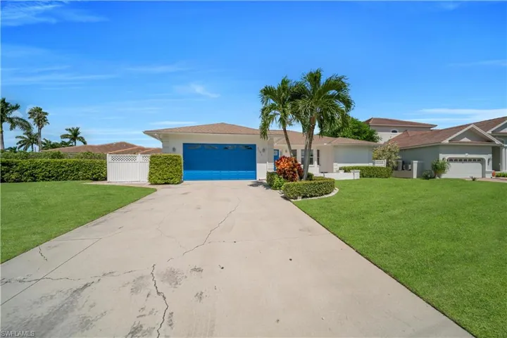 Single story home with concrete driveway, an attached garage, stucco siding, and a gate