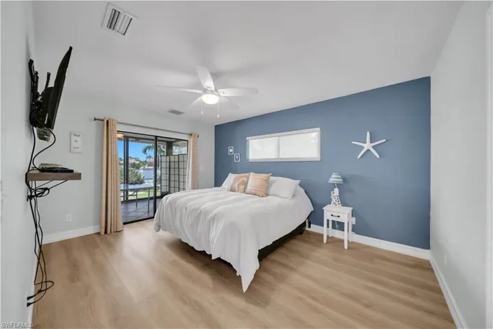 Bedroom with access to exterior, light wood finished floors, and a ceiling fan