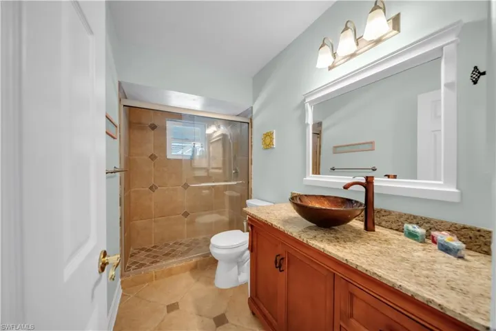 Bathroom featuring a shower stall, vanity, and light tile patterned floors