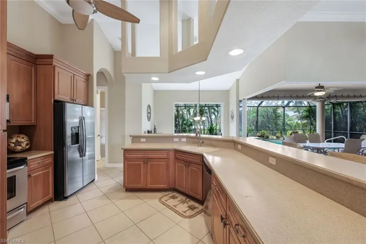 Kitchen featuring crown molding, stainless steel appliances, lots of counter space, breakfast bar & dining area.