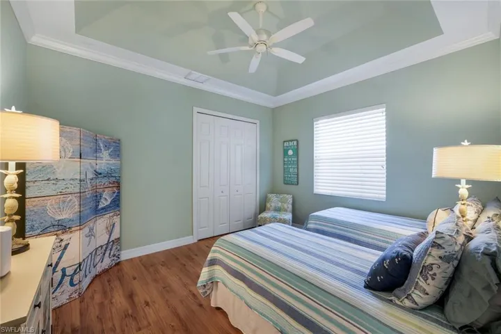 Guest Bedroom #2 with wood flooring and tray ceilinig