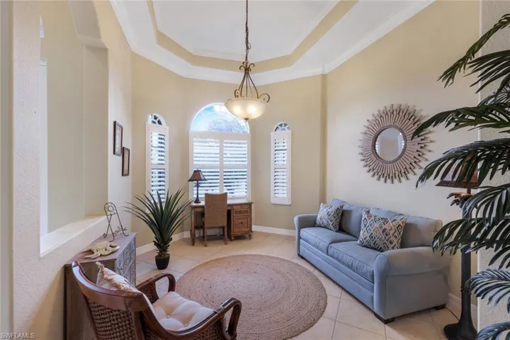 Den or Formal Dining Room at the front of the home has tray ceiling, decorative windows and plantation shutters