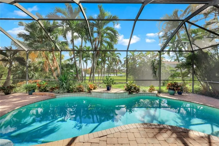 Sparkling, custom pool with a lovely view of green space, landscaping and pond