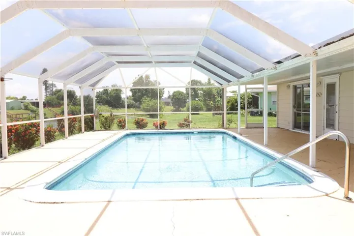 View of pool featuring a lawn, a lanai, and a patio