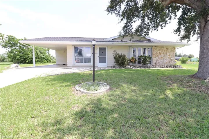View of front of home featuring a front lawn and a carport