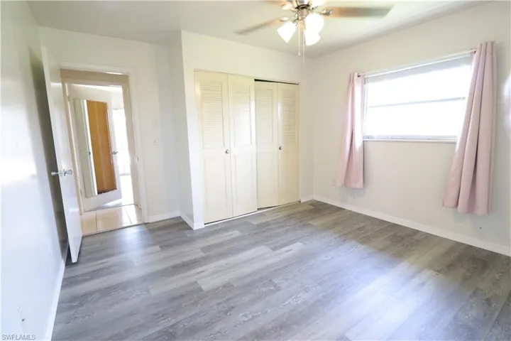 Unfurnished bedroom with ceiling fan, a closet, and hardwood / wood-style flooring
