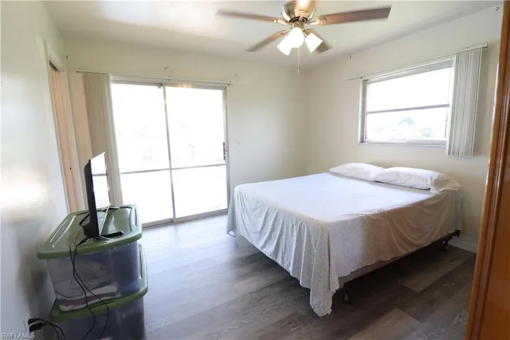 Bedroom featuring ceiling fan, access to outside, and hardwood / wood-style flooring
