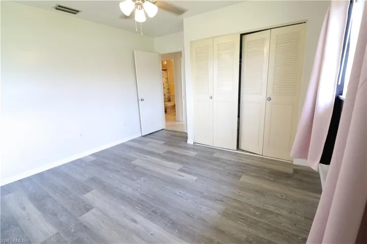 Unfurnished bedroom with hardwood / wood-style floors, a closet, and ceiling fan