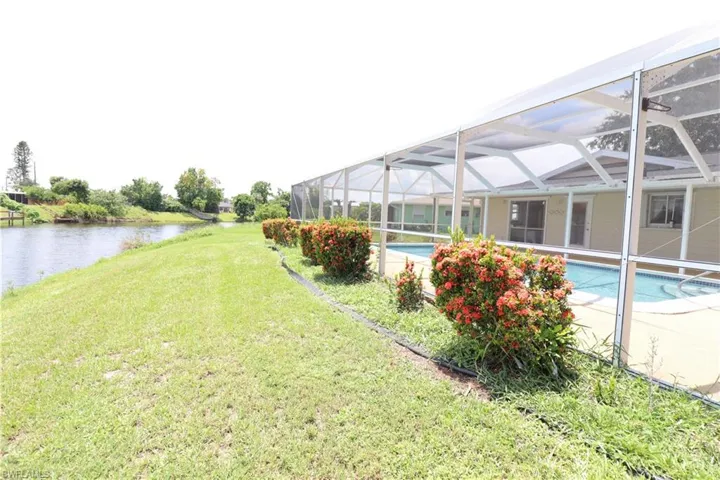 View of yard with enclosure and a water view