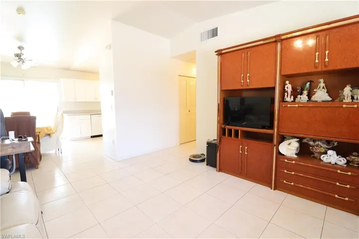 Living room with ceiling fan and light tile patterned floors