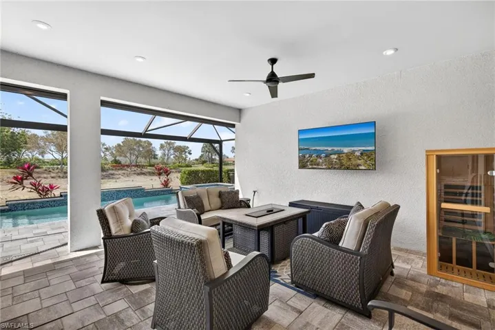 View of patio featuring an outdoor living space, a screened in enclosure, ceiling fan, and a pool with connected hot tub