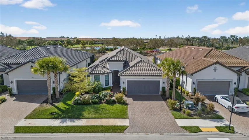 Mediterranean / spanish-style home featuring stucco siding, a garage, a tile roof, and driveway