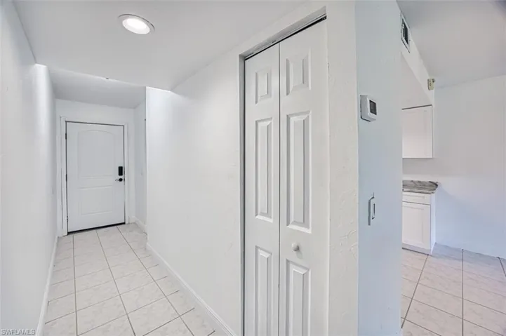 Hall featuring light tile patterned floors and baseboards