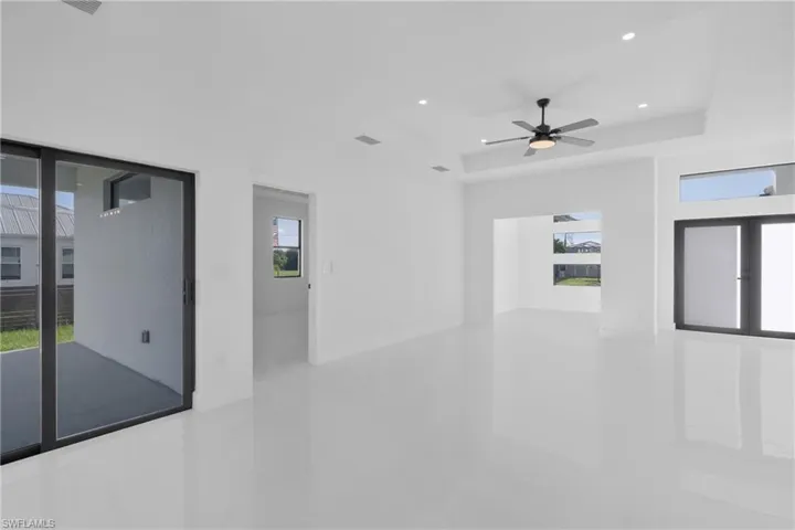 Empty room featuring ceiling fan and a tray ceiling